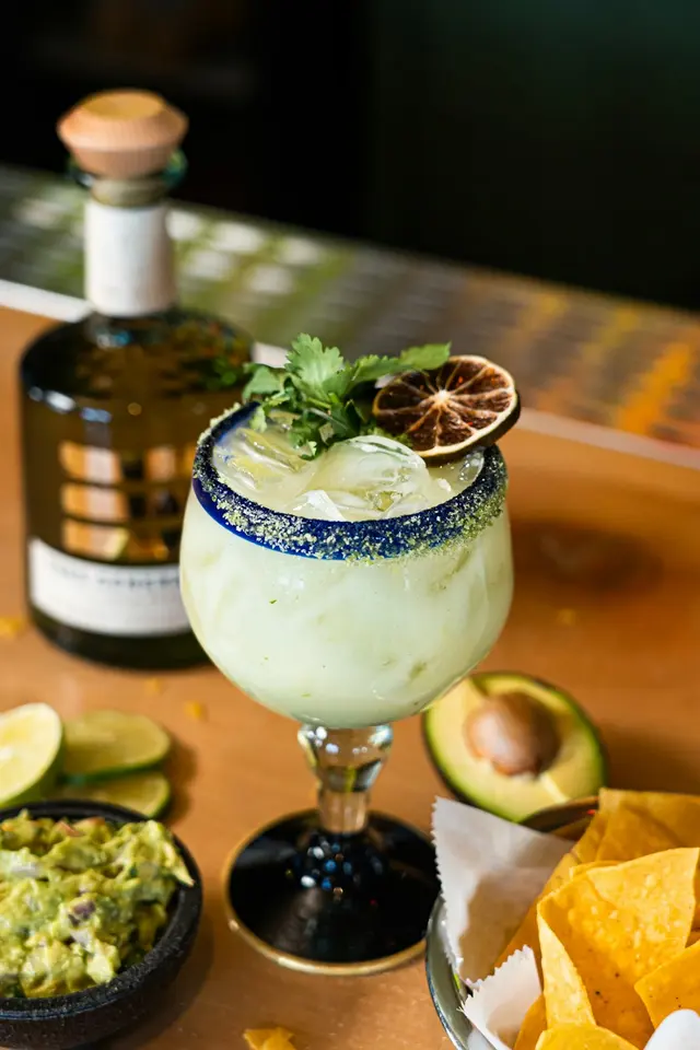 A citrus cocktail with a salted rim and fresh lime